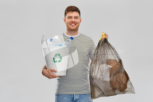 Image of smiling man sorting paper and plastic waste