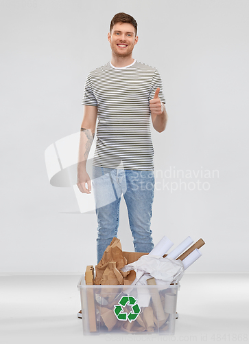 Image of man sorting paper waste and showing thumbs up