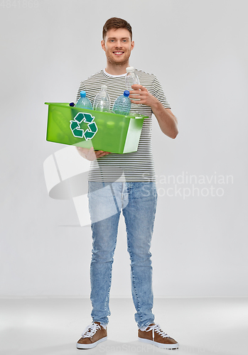 Image of smiling young man sorting plastic waste