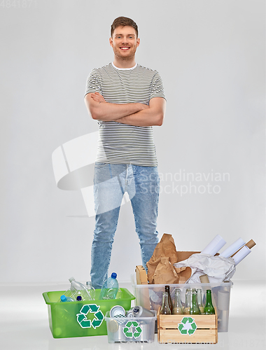 Image of smiling man sorting paper, metal and plastic waste