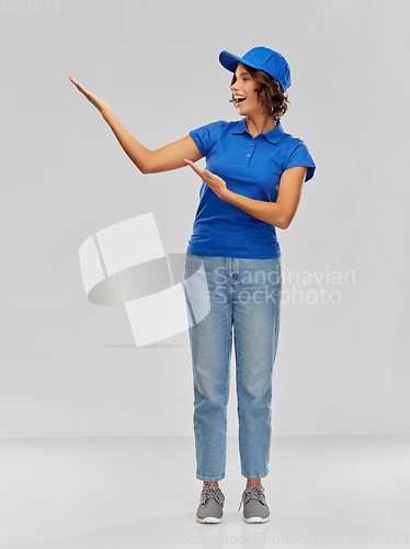 Image of happy smiling delivery woman in blue uniform