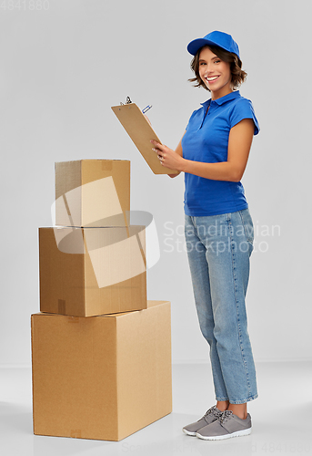 Image of happy delivery girl with boxes and clipboard