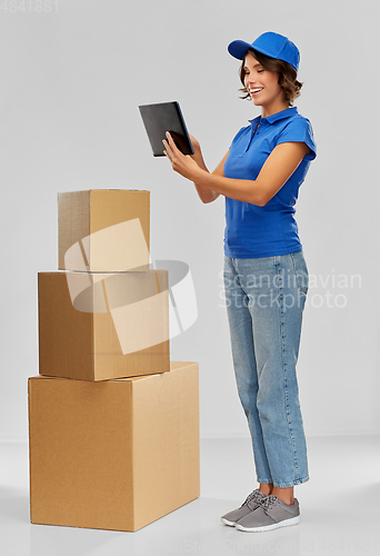 Image of delivery girl with parcel boxes and tablet pc