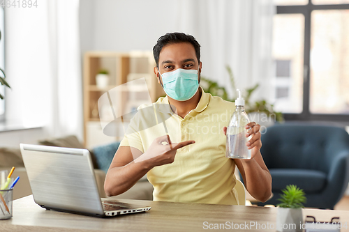 Image of man in mask with hand sanitizer at home office