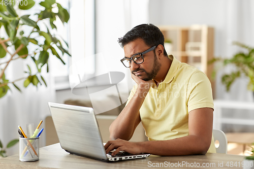 Image of bored man with laptop working at home office