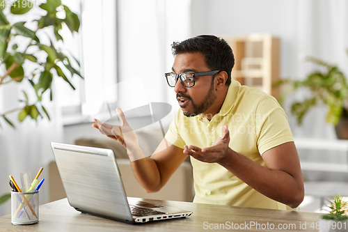 Image of stressed man with laptop working at home office