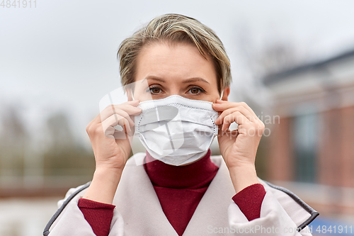 Image of young woman wearing protective medical mask