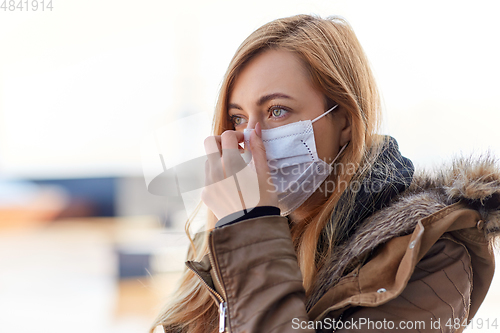 Image of young woman wearing protective medical mask