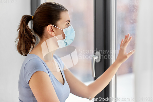 Image of sick young woman wearing protective medical mask