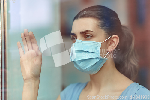 Image of sick young woman wearing protective medical mask