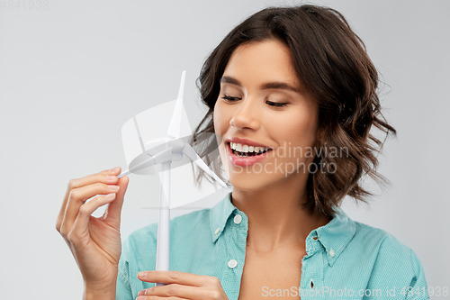 Image of happy smiling young woman with toy wind turbine