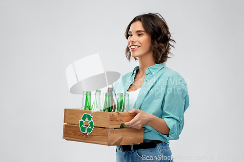 Image of smiling young woman sorting glass waste