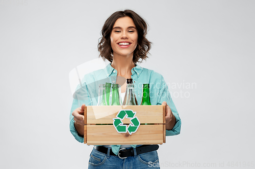 Image of smiling young woman sorting glass waste