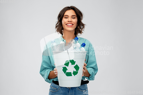 Image of smiling young woman sorting plastic waste