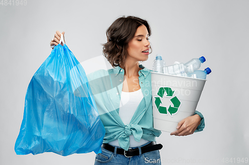 Image of smiling woman sorting plastic waste and trash bag