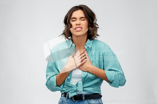 Image of young woman having heartache or heartburn
