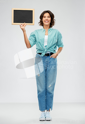 Image of portrait of smiling woman showing black chalkboard