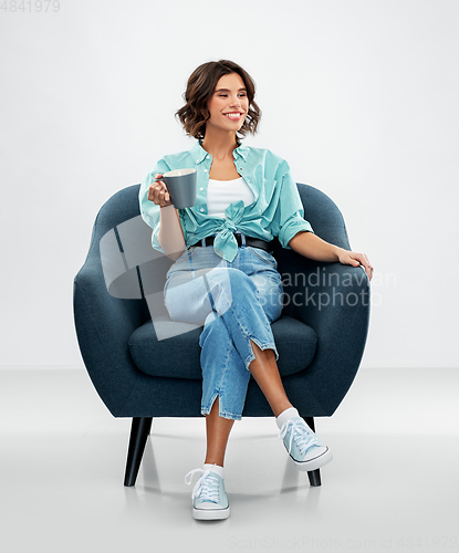 Image of woman sitting in chair with cup of coffee or tea