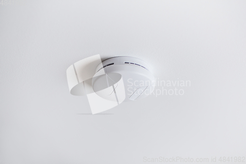 Image of smoke alarm, sensor or detector on white ceiling