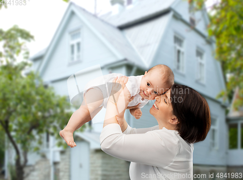 Image of happy middle-aged mother with baby over house