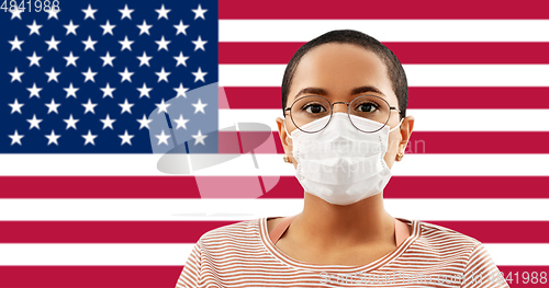 Image of african american woman in mask on flag of america