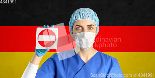 Image of german doctor or nurse in mask showing stop sign