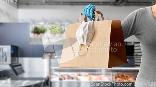 Image of woman with food in paper bag, face mask and gloves