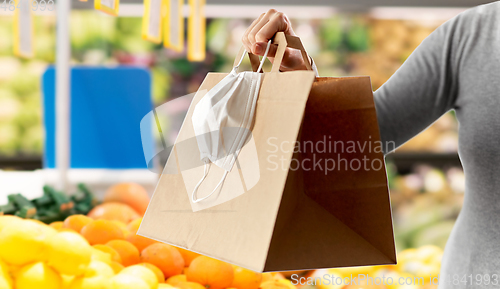 Image of woman with shopping bag and mask at grocery