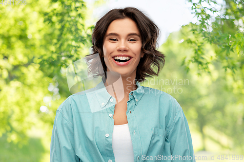 Image of smiling young woman over green natural background