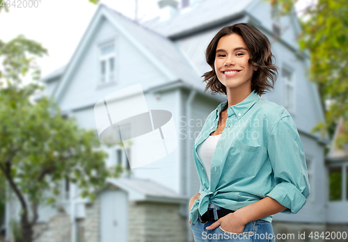 Image of portrait of smiling young woman in turquoise shirt