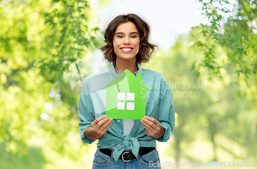 Image of happy woman with green house on natural background