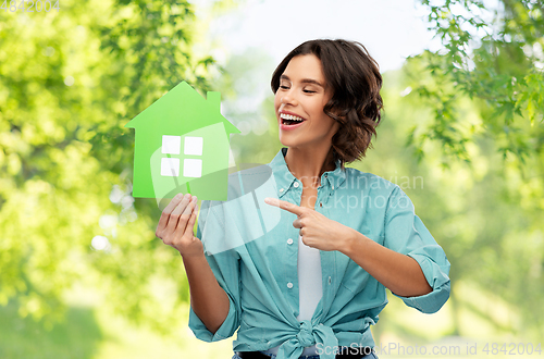 Image of happy woman with green house on natural background
