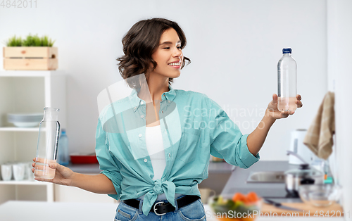 Image of smiling young woman comparing bottles of water