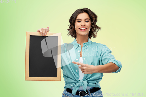 Image of portrait of smiling woman showing black chalkboard