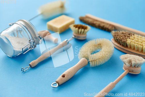 Image of cleaning brushes and soda powder with scoop in jar