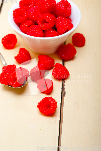 Image of bunch of fresh raspberry on a bowl and white table