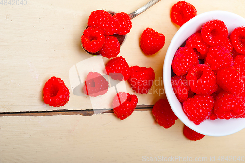 Image of bunch of fresh raspberry on a bowl and white table