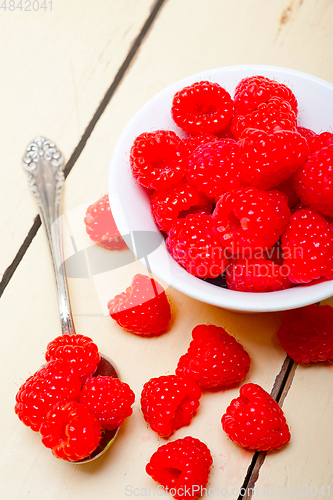 Image of bunch of fresh raspberry on a bowl and white table