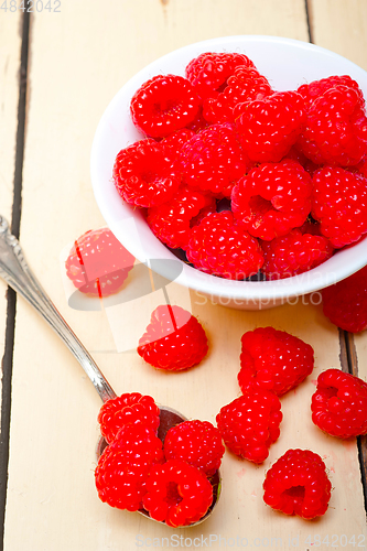 Image of bunch of fresh raspberry on a bowl and white table