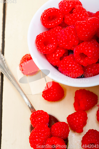 Image of bunch of fresh raspberry on a bowl and white table