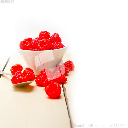 Image of bunch of fresh raspberry on a bowl and white table