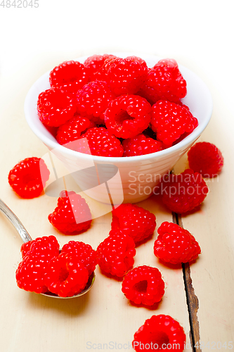 Image of bunch of fresh raspberry on a bowl and white table