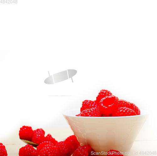 Image of bunch of fresh raspberry on a bowl and white table