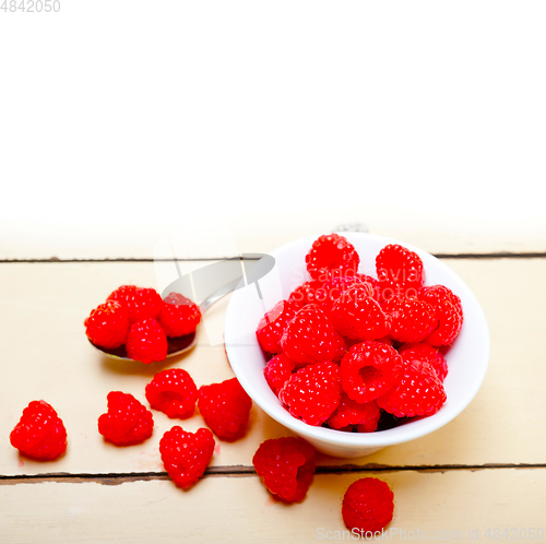 Image of bunch of fresh raspberry on a bowl and white table