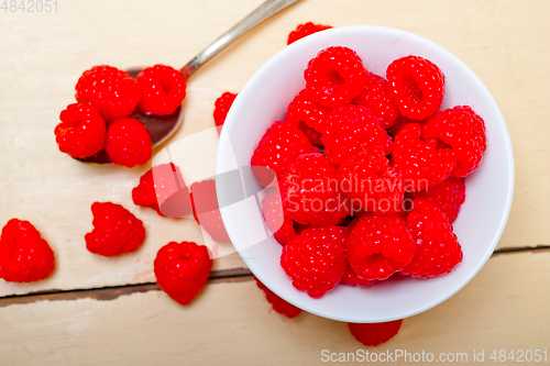 Image of bunch of fresh raspberry on a bowl and white table