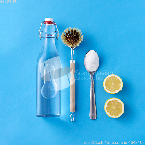 Image of lemons, washing soda, bottle of vinegar and brush
