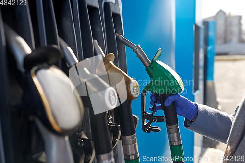 Image of close up of hand in glove with gas nozzle