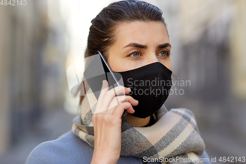 Image of woman in protective reusable mask calling on phone