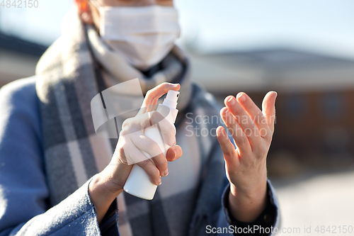 Image of close up of woman spraying hand sanitizer