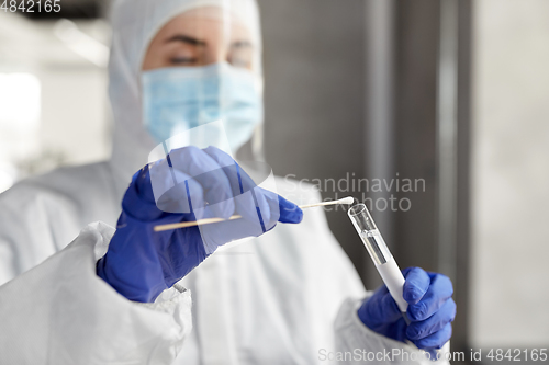 Image of scientist holding beaker with coronavirus test